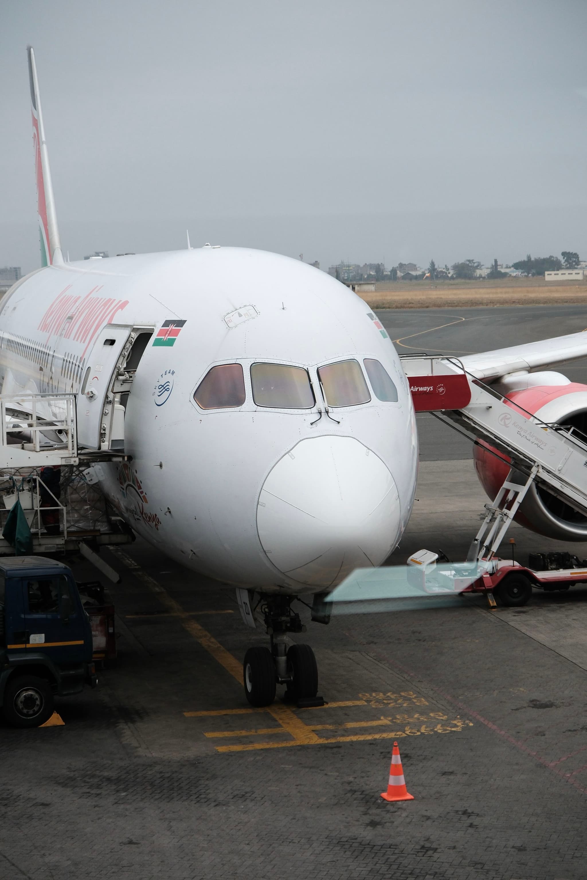 A commercial airplane is parked at an airport gate with a boarding ramp connected to it